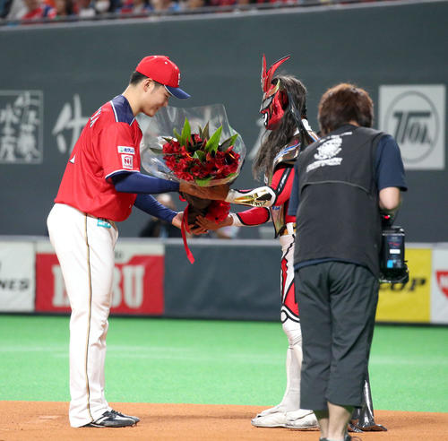 日本ハム対ソフトバンク　試合前、獣神サンダーライガー（右）に花束を贈呈する日本ハム清宮（撮影・佐藤翔太）