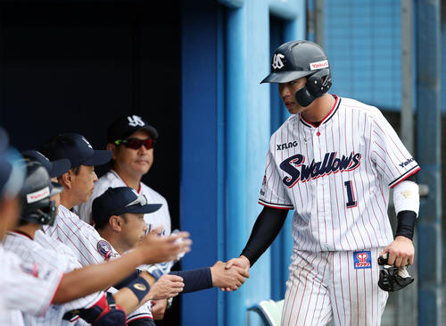 ヤクルト対巨人　1回裏ヤクルト1死一、三塁、村上の適時内野安打で生還し、小川淳二監督（左）とタッチを交わす山田哲（撮影・狩俣裕三）