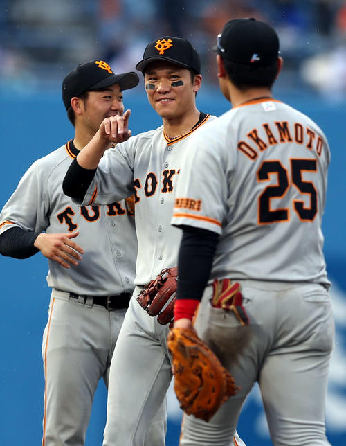 ヤクルト対巨人　試合後、岡本（右）と勝利の喜びを分かち合う坂本勇（中央）（撮影・狩俣裕三）