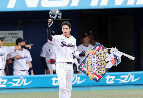 ヤクルト対巨人　1回裏ヤクルト無死、プロ通算1000安打となる中前安打を放ち記念ボードを手にファンの声援に応える山田（撮影・垰建太）