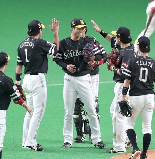 日本ハム対ソフトバンク　試合後、笑顔でナインとハイタッチする甲斐野（中央）（撮影・黒川智章）
