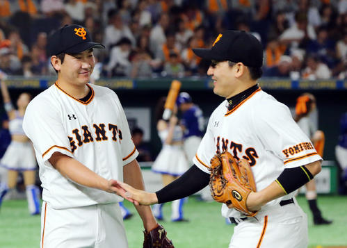 巨人対中日　4回表中日の攻撃を無失点に抑えた巨人菅野（左）は笑顔で丸とタッチを交わす（撮影・垰建太）