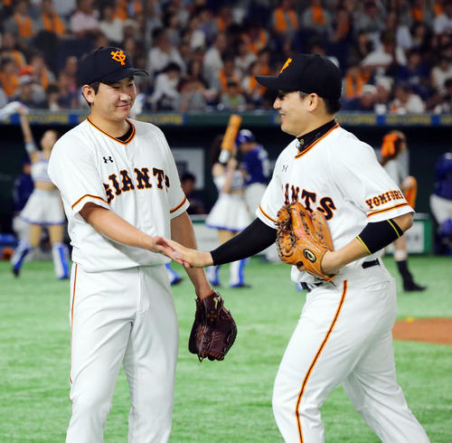 巨人対中日　4回表中日の攻撃を無失点に抑えた巨人菅野（左）は笑顔で丸とタッチを交わす（撮影・垰建太）