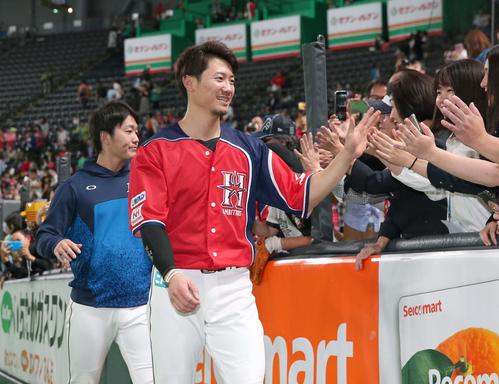日本ハム対西武　試合後、ファンとハイタッチする西川（手前）と玉井（撮影・黒川智章）
