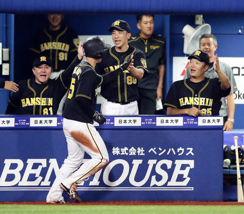 DeNA対阪神　11回表阪神無死三塁、糸原の右犠飛で勝ち越しの生還をした近本（手前）を笑顔で迎える矢野監督（中央）ら阪神ベンチ（撮影・浅見桂子）