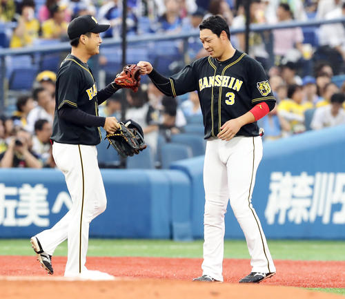 DeNA対阪神　1回表阪神の攻撃後、先制適時二塁打を放った大山（右）はグラブを持ってきた近本とグータッチ（撮影・浅見桂子）