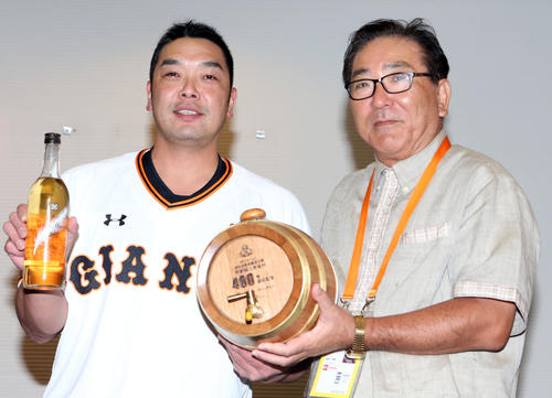 島袋伊江村長（右）から伊江島産ラム酒と通算400号の記念樽をプレゼントされる阿部（撮影・狩俣裕三）