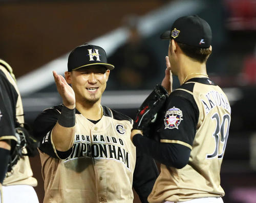 楽天対日本ハム　勝利し笑顔でタッチを交わす日本ハムの中田（左）と秋吉（撮影・足立雅史）