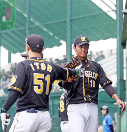 6回を投げ終え、伊藤隼（左）とタッチを交わす藤浪（撮影・狩俣裕三）