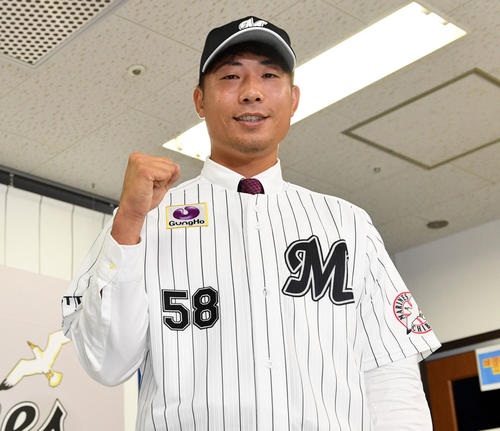 阪神からトレードでロッテに入団した石崎はユニホーム姿でポーズを決める（撮影・滝沢徹郎）