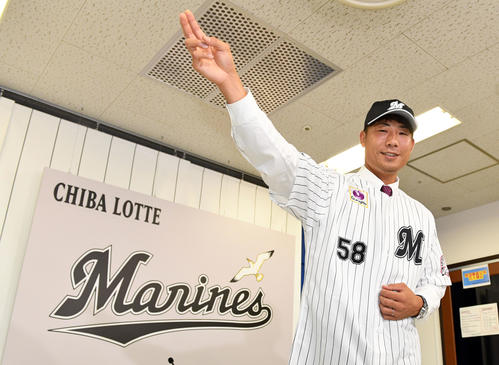 阪神からトレードでロッテに入団した石崎はユニホーム姿でポーズを決める（撮影・滝沢徹郎）