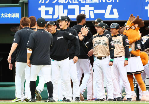 連勝を飾り選手をタッチで迎える栗山監督（左から3人目）（撮影・足立雅史）