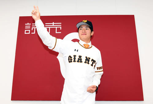 巨人の球団旗の前でポーズを決める古川（撮影・たえ見朱実）