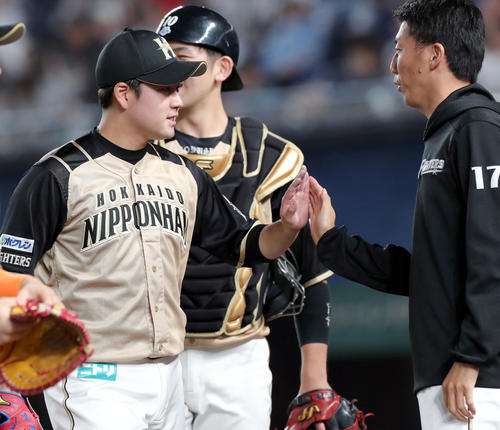 ロッテ対日本ハム　日本ハム堀を出迎える浦野（右）（撮影・佐藤翔太）