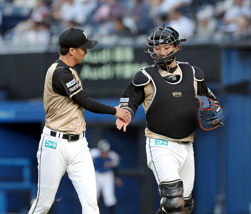 ロッテ対日本ハム　タッチを交わしながらベンチに戻る日本ハム浦野と宇佐見（右）（撮影・佐藤翔太）