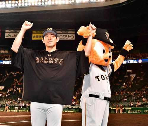 阪神対巨人　今季4勝目を挙げた巨人先発の桜井（左）はジャビットとファンの声援に応える（撮影・小沢裕）