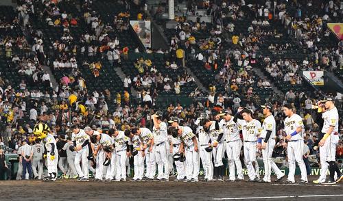 阪神対巨人　巨人に3連敗し空席の目立つスタンドを背にあいさつする矢野監督（左）らナイン（撮影・上田博志）