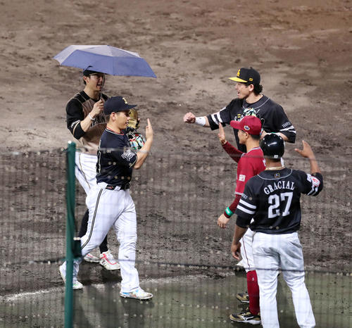 全パ対全セ　5回の守備を終えた全パの日本ハム西川（左奥）はオリックス吉田正（同手前）と相合い傘でベンチに戻る（撮影・垰建太）