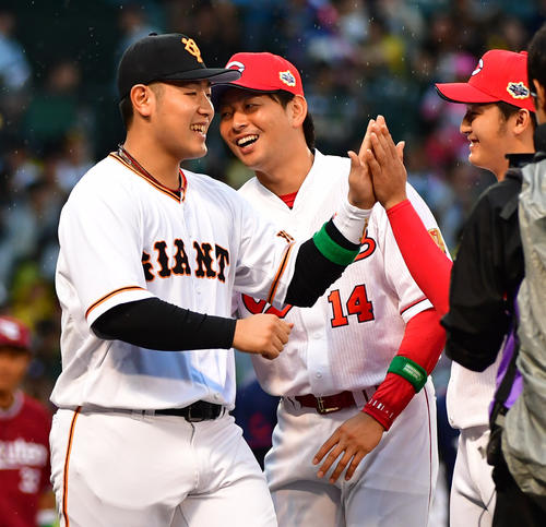 全セ対全パ　選手紹介でタッチを交わす巨人岡本（左）と広島大瀬良（撮影・清水貴仁）