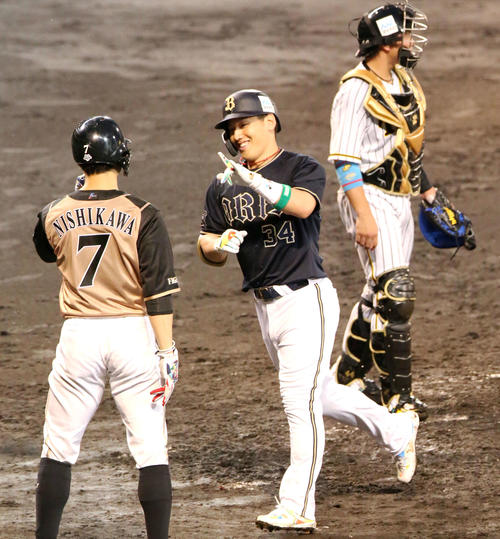 オールスター第2戦　3回表全パ1死一塁、オリックス吉田正尚（中央）は右越え2点本塁打を放ち日本ハム西川遥輝（手前）の出迎えに笑顔を見せる（撮影・上山淳一）