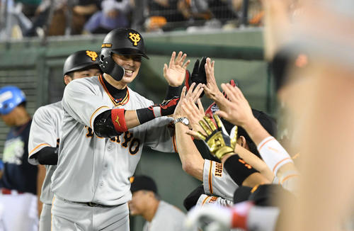 ヤクルト対巨人　11回表巨人無死三塁、2点本塁打を放った亀井はチームメートとタッチをかわす（撮影・山崎安昭）