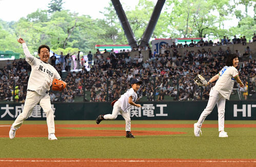 西武対ロッテ　始球式で投球する西武OBの東尾氏（左）。中央は孫の理汰郎くん。右は東尾理子さん（撮影・滝沢徹郎）