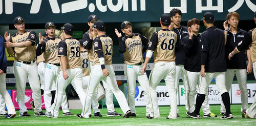 ソフトバンク対日本ハム　ナインを出迎える栗山英樹監督（中央）（撮影・栗木一考）