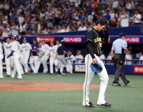 中日対阪神　9回裏中日1死満塁、アルモンテにサヨナラとなる押し出し四球を与え、喜ぶ中日ナインを背にがっくりと引き揚げる小野（撮影・前田充）
