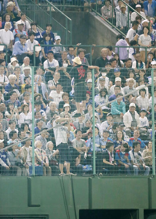 中日対阪神　7回裏開始前、一塁側ベンチ上のフェンスによじ登る男性が登場するが、場内係員に制止され下へ降りる（撮影・加藤哉）