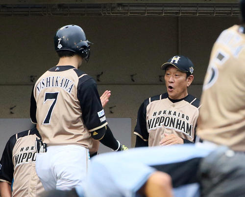 1回表日本ハム無死、西川遥輝は右越えに先制ソロ本塁打を放ち栗山英樹監督（右）の出迎えを受ける（撮影・栗木一考）