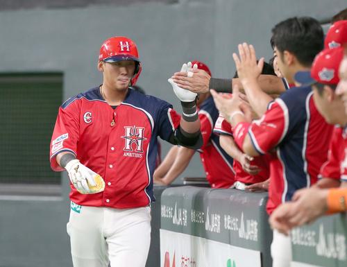 日本ハム対ロッテ　8回裏、本塁打を放ちナインに出迎えられる中田（撮影・黒川智章）
