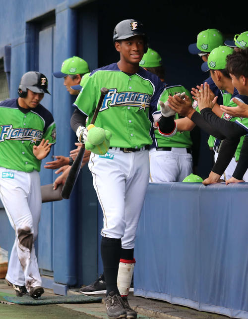 イースタン・リーグ　日本ハム対DeNA　1回裏日本ハム2死一、二塁で左翼スタンドへ逆転の3点本塁打を放ち、チームメートとハイタッチする日本ハム万波（中央）（撮影・山崎純一）