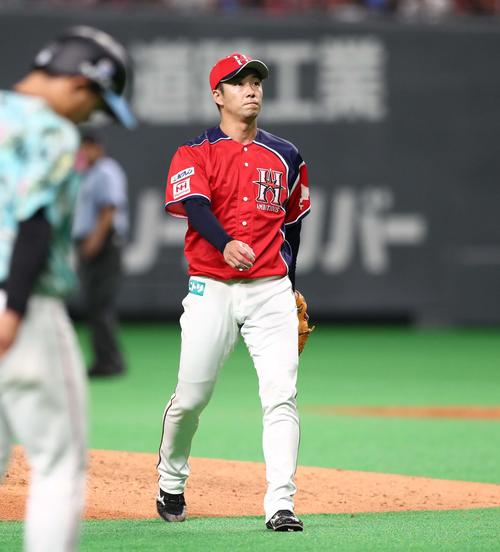 日本ハム対ロッテ　7回表、田村（左）に適時二塁打を浴びる斎藤（撮影・黒川智章）