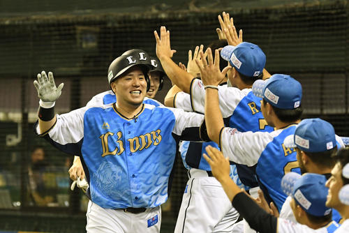 西武対オリックス　6回裏西武無死一、三塁、30号となる逆転の左越え3点本塁打を放った山川（手前左）は生還しナインとタッチを交わす（撮影・滝沢徹郎）　