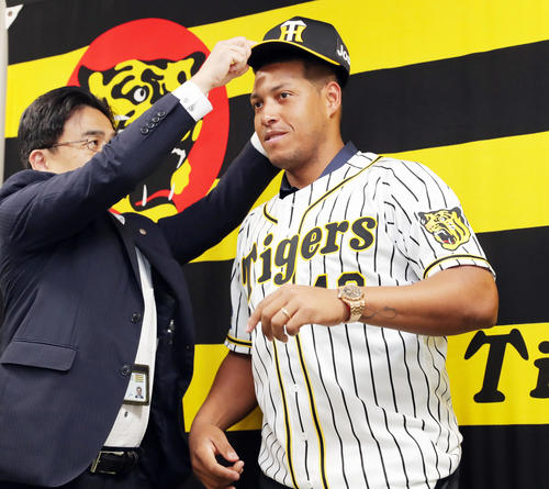 入団会見を行い、谷本球団副社長（左）に帽子をかぶせてもらう阪神ソラーテ（撮影・前田充）