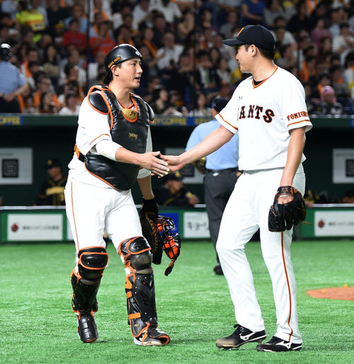 巨人対阪神　6回表終了時、タッチを交わす巨人小林（左）と菅野（撮影・横山健太）