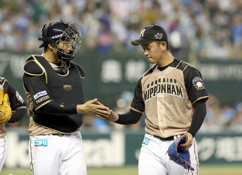 西武対日本ハム　日本ハム宇佐見（左）とタッチを交わしながらベンチに戻る北浦（撮影・佐藤翔太）