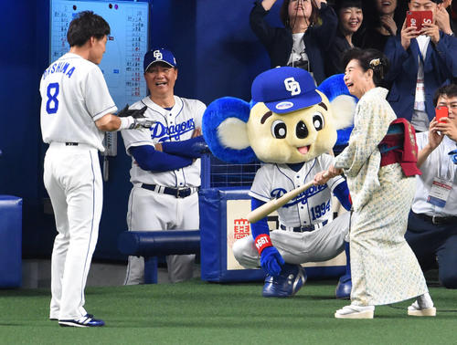 試合開始前、大島のバットを振る中村玉緒。ベンチで笑顔の与田監督（撮影・森本幸一）