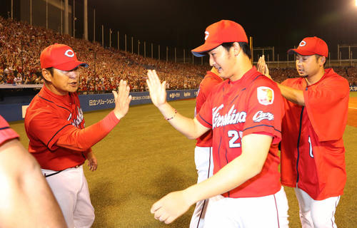 6勝目を挙げた床田とタッチする広島の緒方監督（左）（撮影・丹羽敏通）