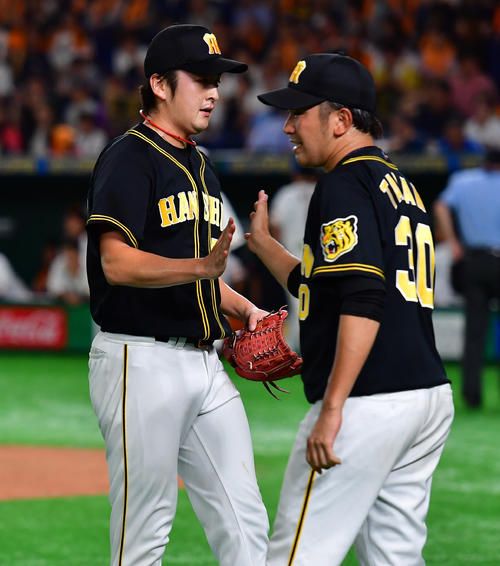 巨人対阪神　10回のピンチをしのぎ高野圭佑（右）とタッチを交わす飯田優也（撮影・清水貴仁）