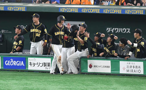巨人対阪神　1回表阪神無死三塁、糸原の犠飛で生還した近本（左から3人目）はチームメートとタッチをかわす（撮影・山崎安昭）