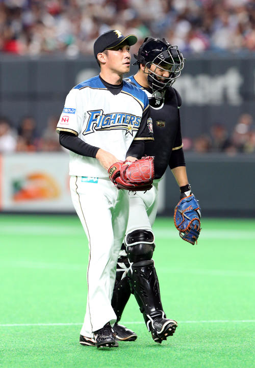 日本ハム対楽天　先制を許しベンチに戻る日本ハム吉川と宇佐見（右奥）（撮影・佐藤翔太）