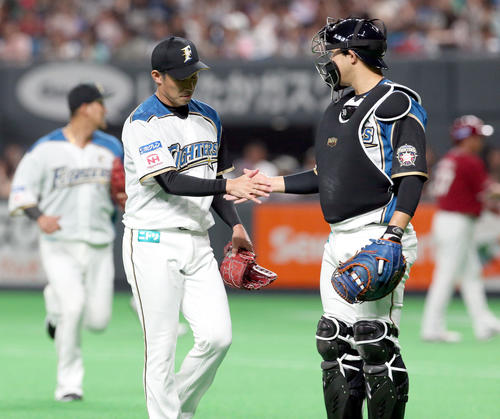 日本ハム対楽天　1回表を無失点に抑えタッチを交わしながらベンチに戻る日本ハム吉川と宇佐見（右）（撮影・佐藤翔太）
