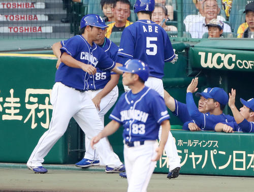 阪神対中日　1回表中日1死二塁、与田監督（右から3人目）はアルモンテの左前適時打で生還した平田（左）とタッチする（撮影・加藤哉）