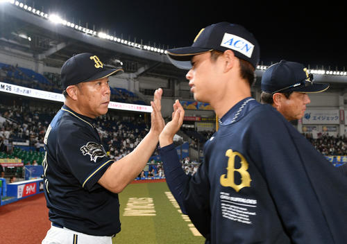 ロッテ対オリックス　試合後、勝利投手のオリックス山岡（右手前）とタッチを交わす西村監督（撮影・滝沢徹郎）