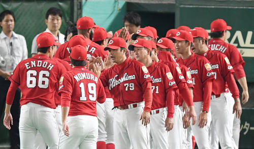 巨人対広島　巨人に勝利し、勝利投手の野村らナインとタッチして喜ぶ緒方監督（中央右）（撮影・加藤諒）