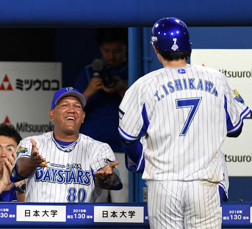 DeNA対巨人　6回裏DeNA1死三塁、嶺井の右前適時打で生還した石川（右）を笑顔で迎えるラミレス監督（撮影・横山健太）