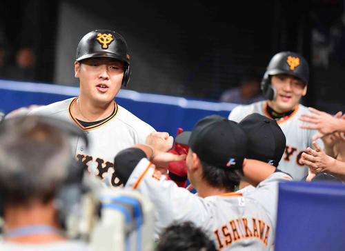 中日対巨人　4回表巨人1死一塁、岡本は右越えに2点本塁打を放ちベンチのナインの祝福を受ける。後方右は丸（撮影・小沢裕）