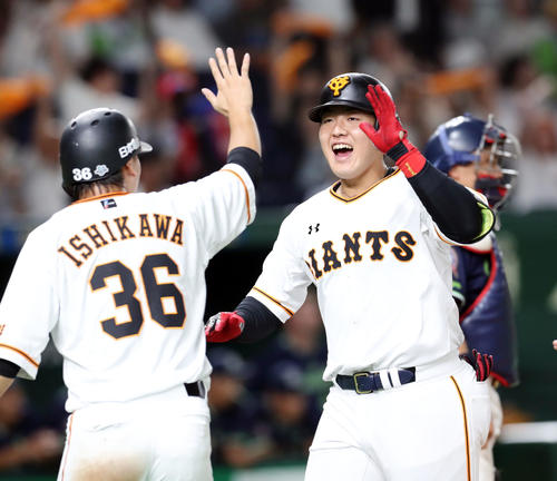 巨人対ヤクルト　8回裏巨人1死一、二塁、右中間に同点となる3点本塁打を放ち笑顔で石川とタッチを交わす岡本（右）（撮影・垰建太）