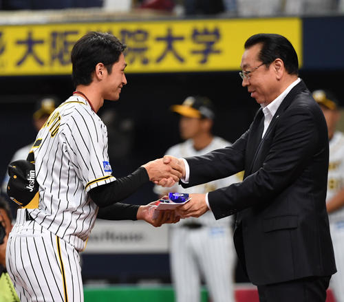 阪神対広島　7月度月間最優秀選手賞に輝いた近本光司（左）は阪神・揚塩健治代表取締役社長と握手をかわす（撮影・奥田泰也）